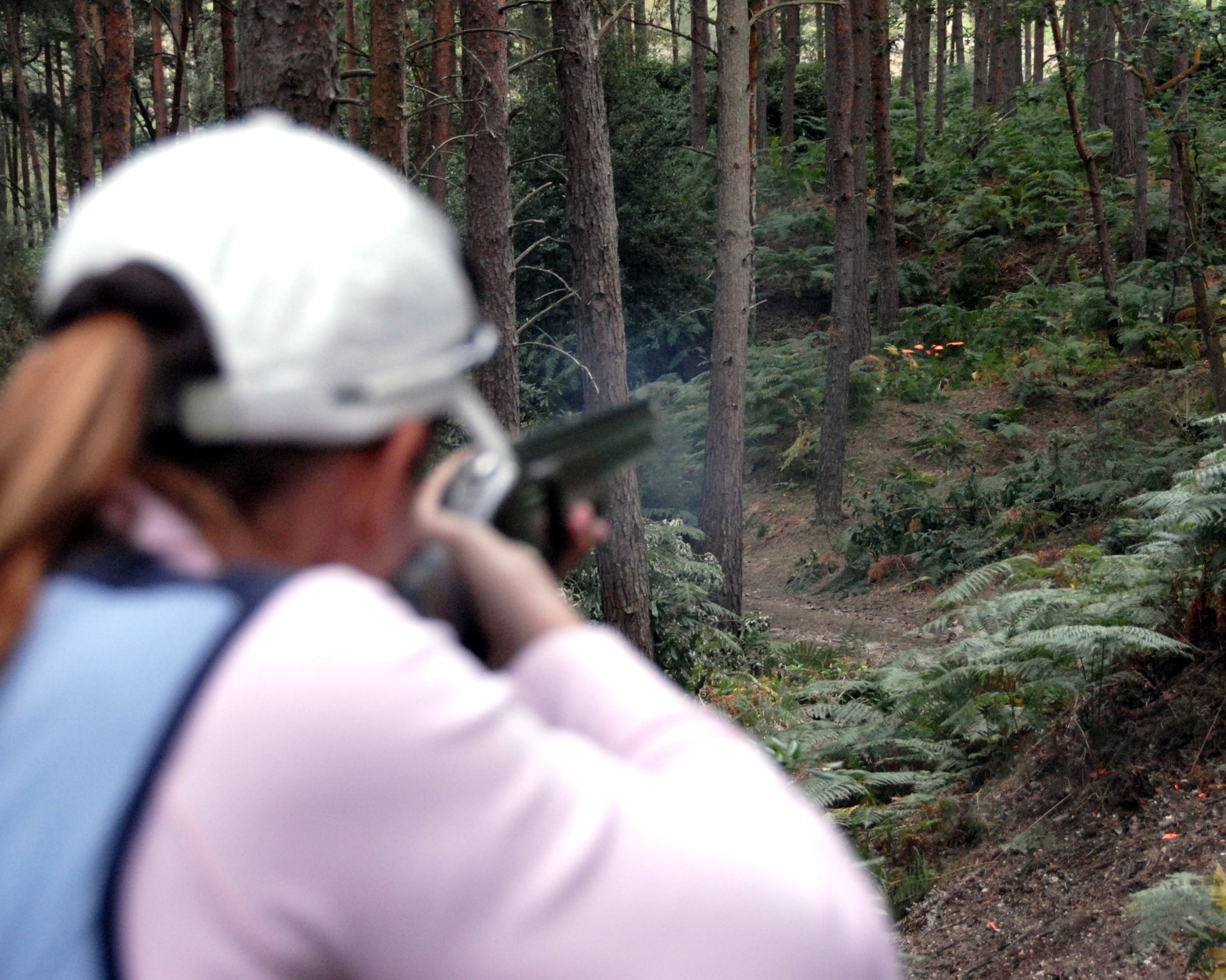 Clay shooter hitting clay target from a personal use clay pigeon trap